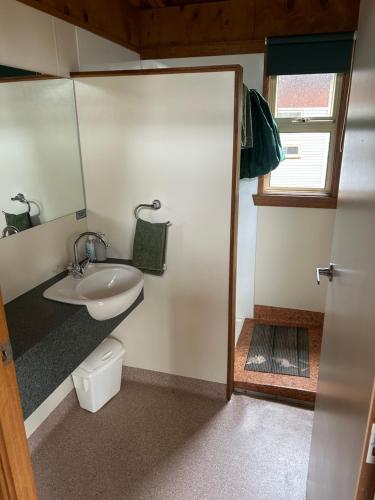 a small bathroom with a sink and a mirror at Base Camp Tasmania in New Norfolk