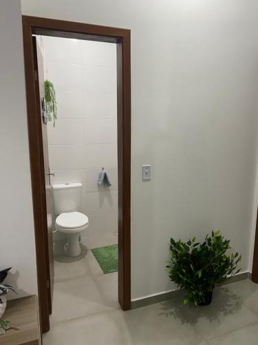 a bathroom with a toilet and a glass door at Aconchegante Casa de praia in Matinhos