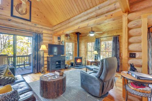 a living room with a couch and a fireplace in a log cabin at Blue Ridge Log Cabin with Hot Tub and Game Room! in Blue Ridge