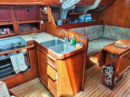 a kitchen with a sink and a couch in a boat at Boat Vogue à Lame in Gourbeyre