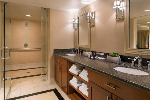 a bathroom with two sinks and a shower at Bakersfield Marriott at the Convention Center in Bakersfield