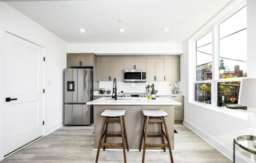 a kitchen with a refrigerator and two bar stools at Mary's Stay Brookland in Washington
