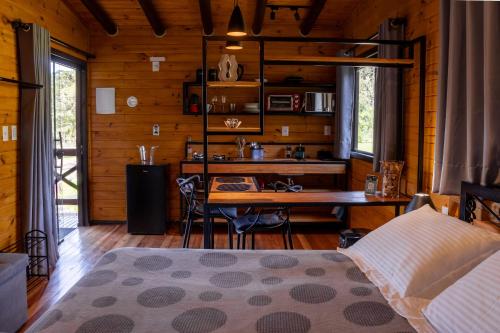 a bedroom with a desk and a bed and a table at La Bella Vista in Urubici