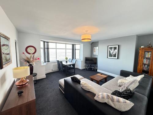 ein Wohnzimmer mit einem Sofa und einem Tisch in der Unterkunft Seaviews Apartment 2, Whitley Bay Sea Front in Whitley Bay