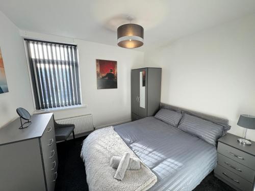 a bedroom with a bed with a cross on it at Seaviews Apartment 2, Whitley Bay Sea Front in Whitley Bay