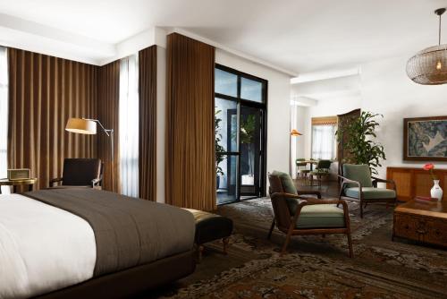 Habitación de hotel con cama, escritorio y sillas en The Aster en Los Ángeles