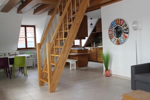 a kitchen and a living room with a wooden staircase at Ferienwohnung 2 ANNA IFF in Würzburg