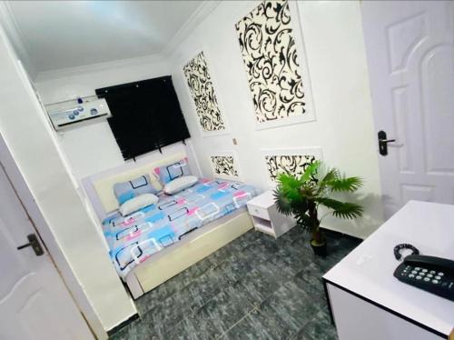 a small bedroom with a bed and a desk at White Emirates Hotel and Apartment in Lagos