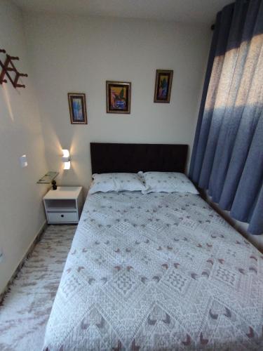 a bedroom with a large bed with blue curtains at Loft em Cobertura in Rio de Janeiro