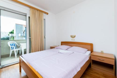 ein Schlafzimmer mit einem großen Bett und einem Balkon in der Unterkunft Apartments Josip S in Lopar