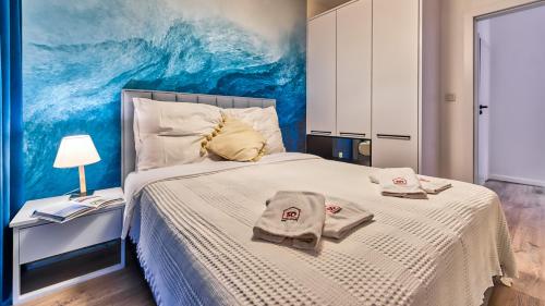 een slaapkamer met een bed met handdoeken erop bij Rezydencja Niechorze 112 z ogródkiem - 5D Apartamenty in Niechorze