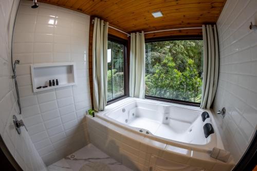 a bath tub in a bathroom with a window at La Bella Vista in Urubici