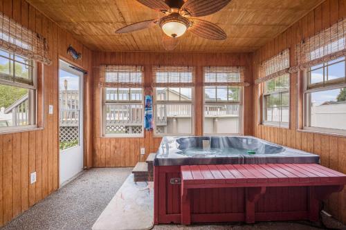 bañera de hidromasaje en una habitación con ventilador de techo en Hot Tub Hideaway 3 BR, en Jeffersonville