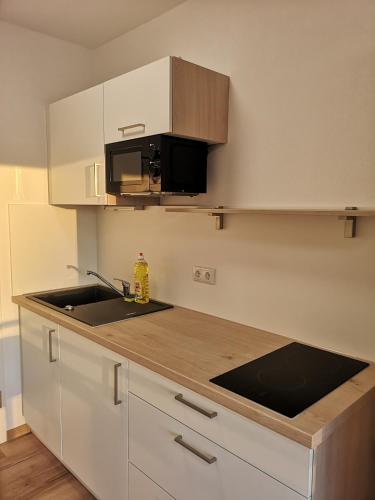 a white kitchen with a sink and a microwave at Modern flat, WIFI, central, calm, clean in Ingolstadt