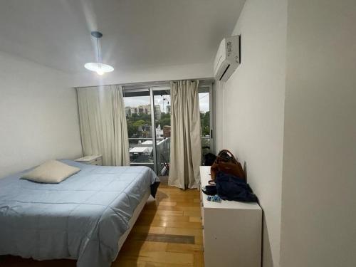 1 dormitorio con cama y ventana grande en Septiembre Station View en Buenos Aires