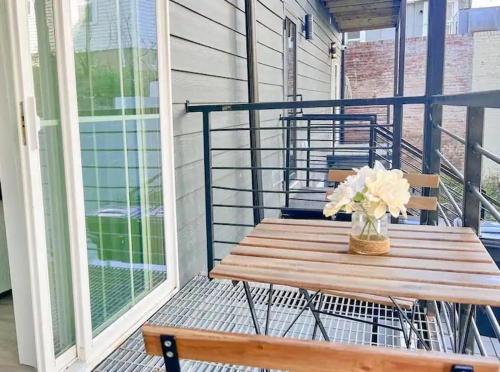 a wooden bench on a porch with a vase of flowers at Mary's Stay Brookland in Washington