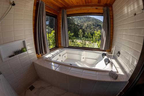 uma banheira na casa de banho com uma janela em La Bella Vista em Urubici