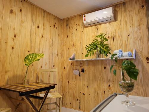 um quarto com paredes de madeira e uma mesa com uma planta em Casa de Dan em Pipa