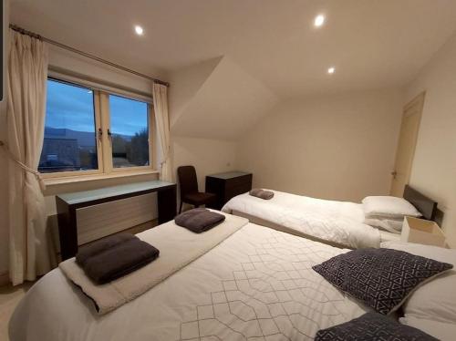 a bedroom with two beds and a window at Beautiful Holiday Cottage near Kenmare in Kenmare