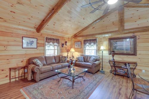 a living room with a couch and a table at Tumbling Shoals Cabin with Fire Pit 1 Mi to Lake in Heber Springs