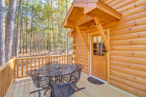 a wooden deck with a table and chairs on it at Tumbling Shoals Cabin with Fire Pit 1 Mi to Lake in Heber Springs