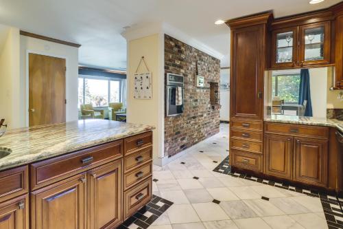 a kitchen with wooden cabinets and a stone wall at Spacious Reno Vacation Rental about 3 Mi to MidTown! in Reno