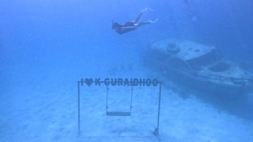 a person is swimming in the water in the ocean at Konut by Thakuru in Guraidhoo