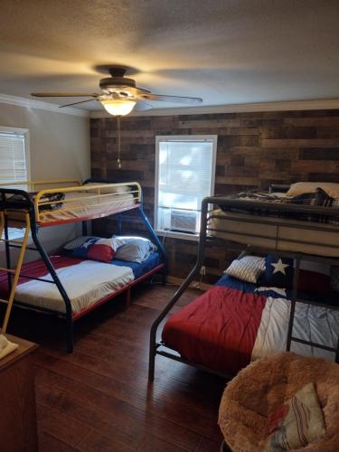 a room with two bunk beds and a ceiling fan at Rustic house on Lake Tawakoni in Hawk Cove