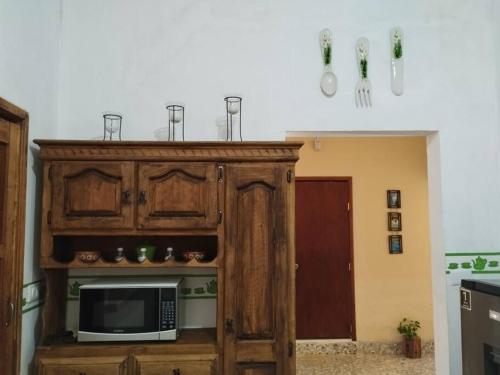 a microwave in a wooden cabinet in a kitchen at Casa Mali, zona centro, con piscina, asador y muy amplia in Ciudad Valles