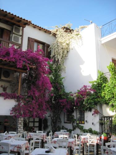 a building with flowers on the side of it at Mouria Hotel in Skiathos Town