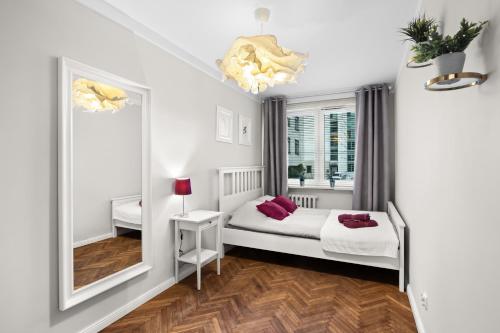 a bedroom with two beds and a mirror at Apartament Warszawa STARE MIASTO in Warsaw