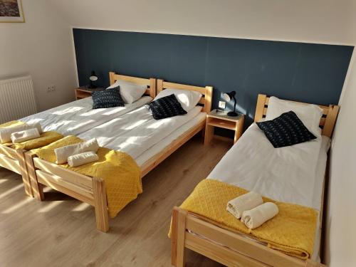 two twin beds in a room with two chairs at Apartamenty Starosądeckie in Stary Sącz