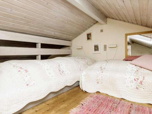 two beds in a room with wooden ceilings at Holiday home Ærøskøbing XI in Ærøskøbing