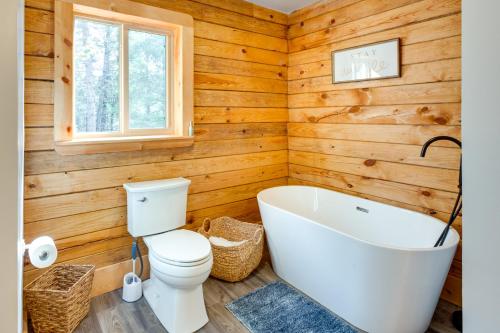 een badkamer met een wit bad en een toilet bij Private Ski-Out Angel Fire Cabin Wraparound Porch in Angel Fire