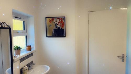 a bathroom with a sink and a toilet and a mirror at Stay in Woking with Chidi in Horsell
