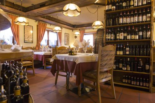 un ristorante con tavolo e alcune bottiglie di vino di Hotel La Baita a Livigno