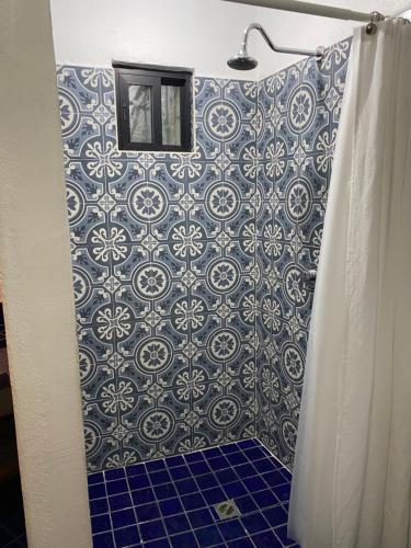 La salle de bains est pourvue d'une douche et de carrelage bleu et blanc. dans l'établissement Posada 1885, à Santiago