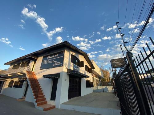 a building with a sign on it on a street at Pousada355 in Passo Fundo