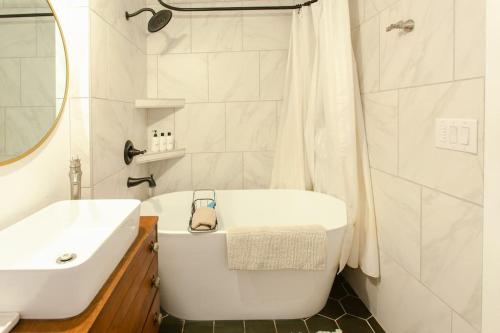a white bathroom with a tub and a sink at Classic & Cozy Apartments - Parking & Close To Dw in Medford