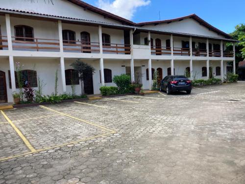 a hotel with a car parked in front of it at Apartamentos Petrópolis in Ubatuba