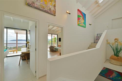 a living room with a staircase and a view of the ocean at Villa Nagabaaja near Anse des Cayes - 230 m² with pool in Anse des Cayes