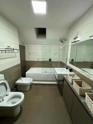 a bathroom with a tub and a toilet and a sink at Primo Classe apartment 1 in Skopje