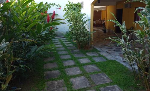 a garden with plants and a stone walkway at Pousada Recanto da Vila in Trancoso