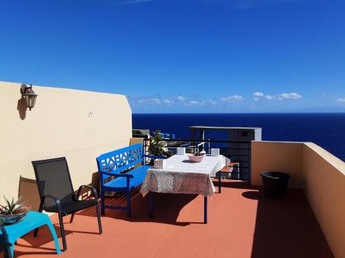 uma varanda com uma mesa e cadeiras e o oceano em CANDELARIA SOL Y MAR em Candelaria