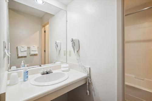 a bathroom with a sink and a phone on the wall at Cedarbrook Two Queen Bed Standard Hotel Room with outdoor heated pool 104 in Killington