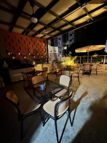 a group of tables and chairs on a patio at night at STUDIO 304 | WIFI 600MB | RESIDENCIAL JC, um lugar para ficar. in Belém