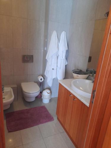 a bathroom with a toilet and a sink at Azoresaccommodation in Lagoa