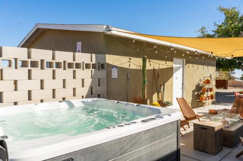 a large hot tub sitting in a backyard at Mojave Lofi - Bright and Airy home 25 min from Joshua Tree National Park - Hot Tub, Cal-King Beds, Game Room in Yucca Valley