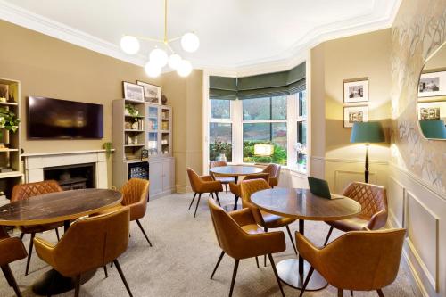 a room with tables and chairs and a fireplace at Fountains Guest House - Harrogate Stays in Harrogate