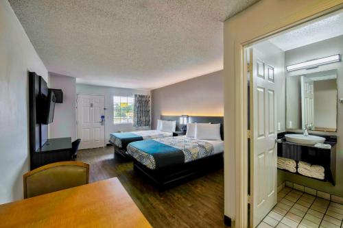 a hotel room with a bed and a bathroom at Studio 6-Pascagoula, MS in Pascagoula